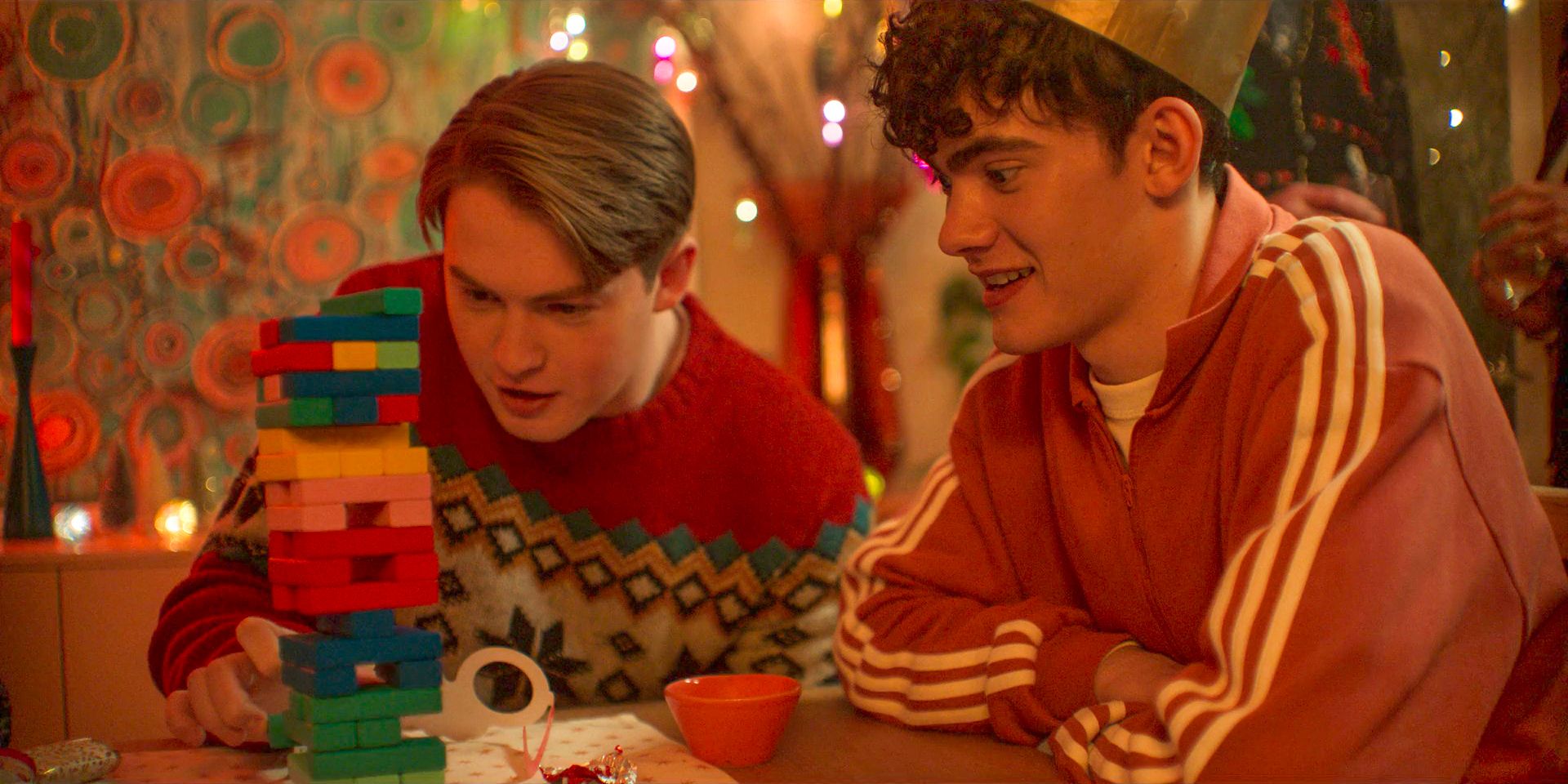 Nick (Kit Connor) and Charlie (Joe Locke) playing Jenga on Christmas in Heartstoppers Season 3 Episode 5