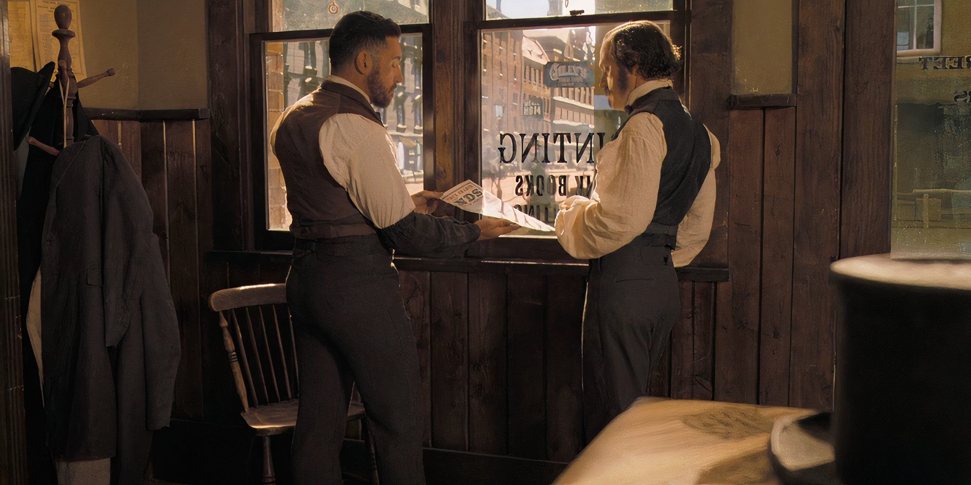 Two men in suits look at a freshly printed flyer in Horizon: An American Saga - Chapter 1