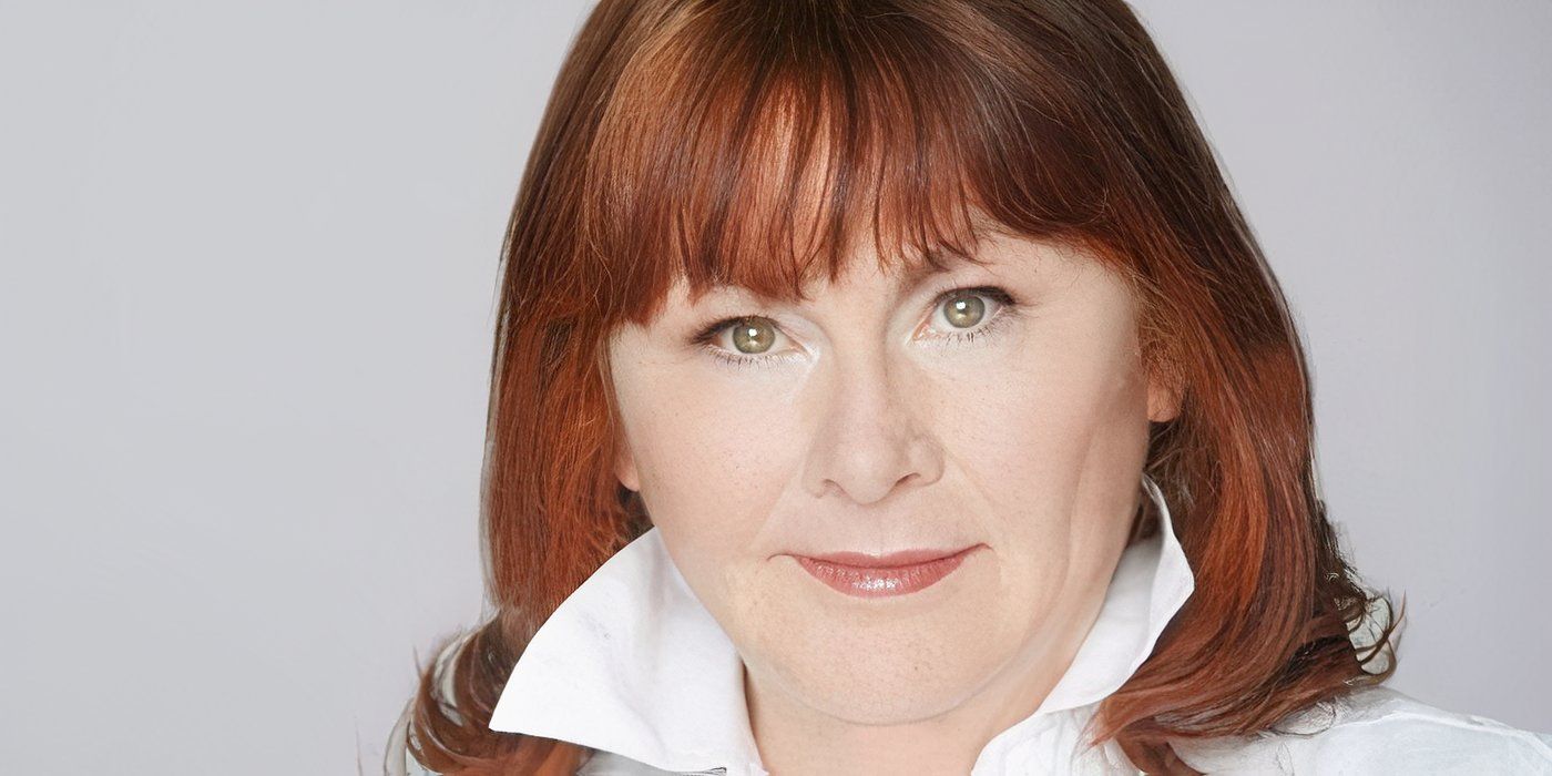 Mary Walsh olha séria diante de um fundo cinza