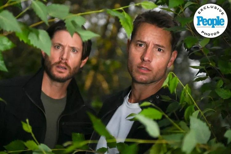 Jensen Ackles as Russell and Justin Hartley as Colt stand among trees and look beyond branches in Tracker season 2