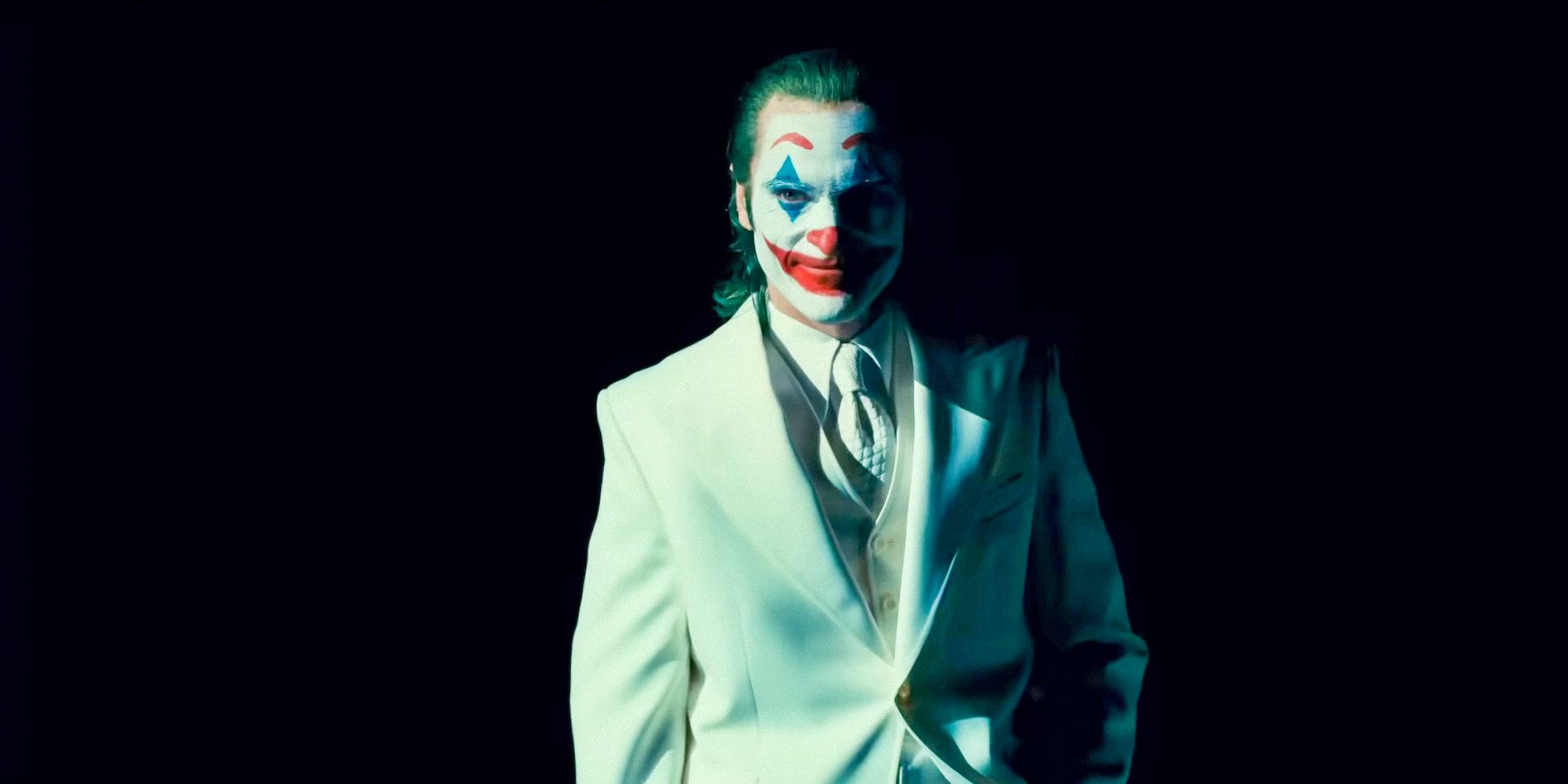 Joaquin Phoenix como Arthur Fleck/Joker no terno branco de Darkness in Joker: Folie à Deux