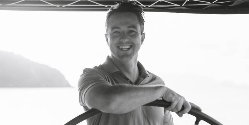 Keith Allen in Below Deck Sailing Yacht black and white photo driving a boat