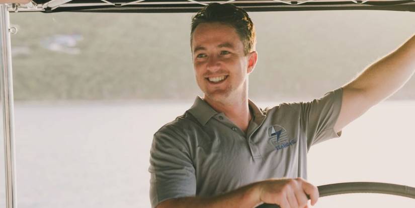 Keith Allen in Below Deck Sailing Yacht smiling while driving a boat
