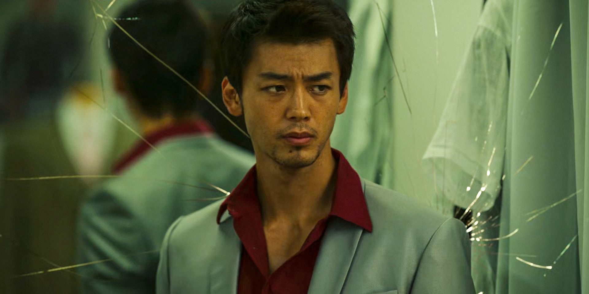 Kazuma (Ryoma Takeuchi) with a broken mirror behind him after a fight in Like a Dragon: Yakuza Season 1 Ep 2