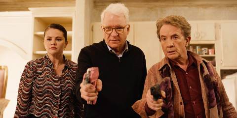 Mabel, Charles, and Oliver stare down someone off camera while Charles and Oliver hold weapons in Only Murders in the Building season 4