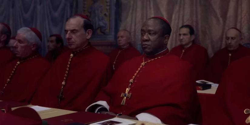Conclave supporting cast sitting together in red robes, including Cardinal Adeyemi