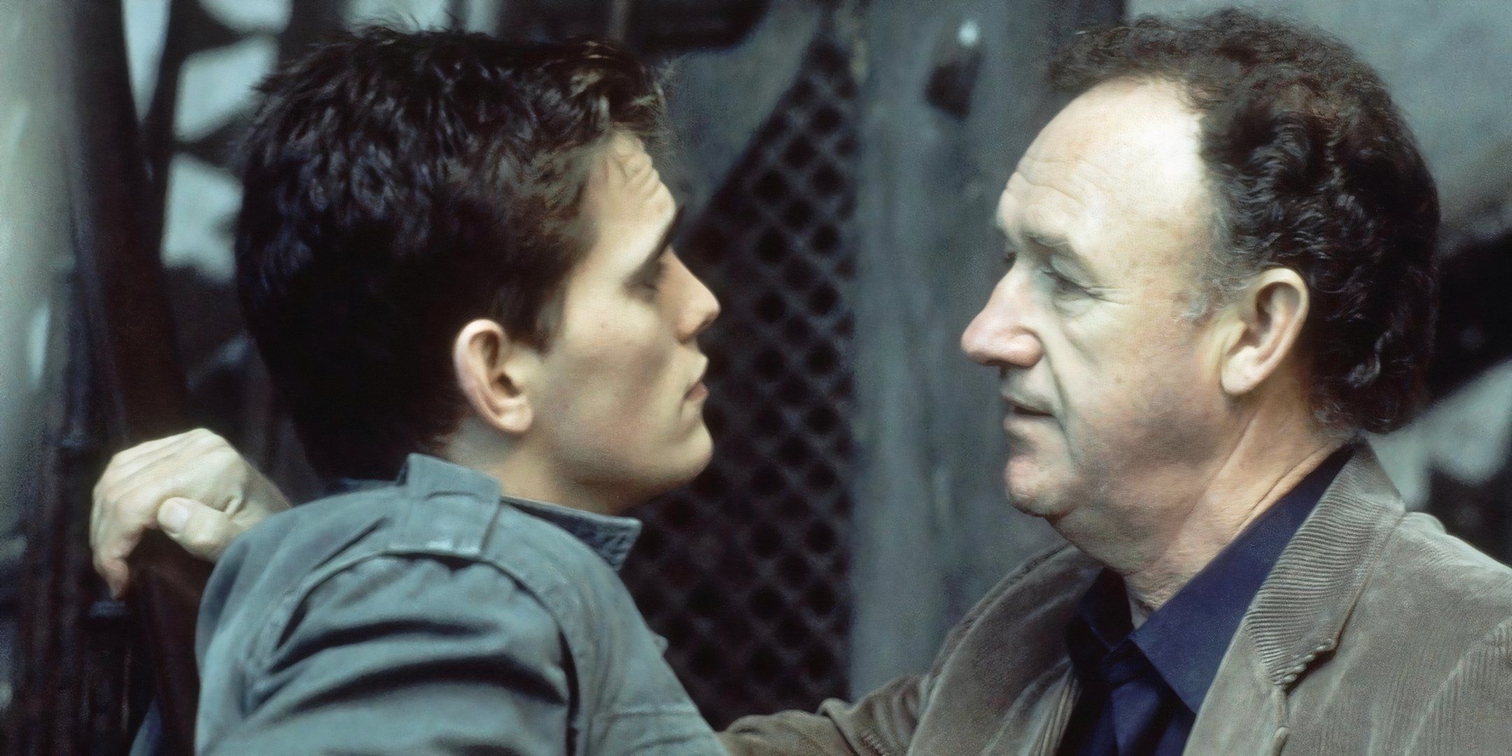 Matt Dillon and Gene Hackman stand in front of one another and talk. 