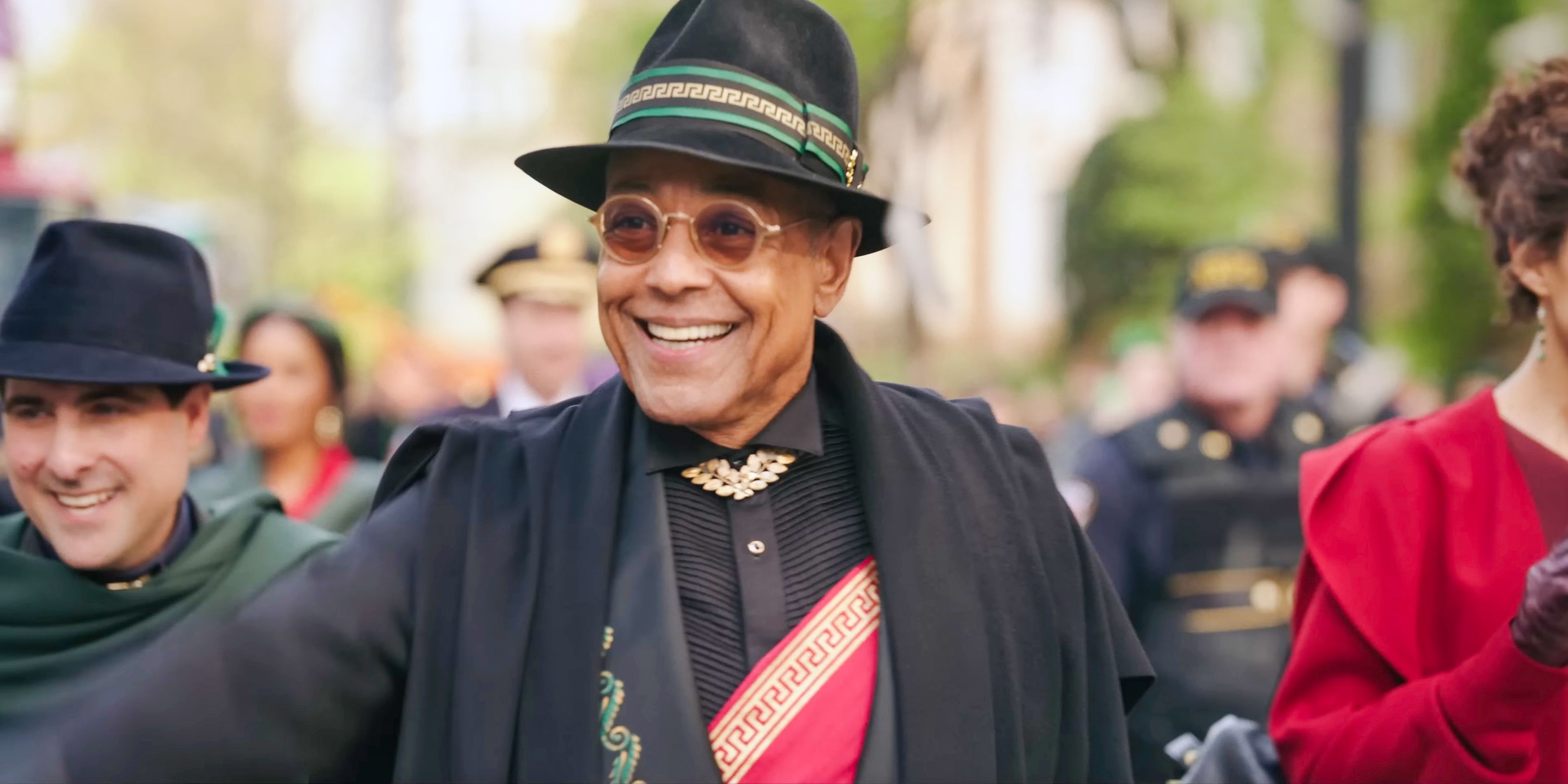 Mayor Cicero (Giancarlo Esposito) smiling and waving to the crowd in Megalopolis