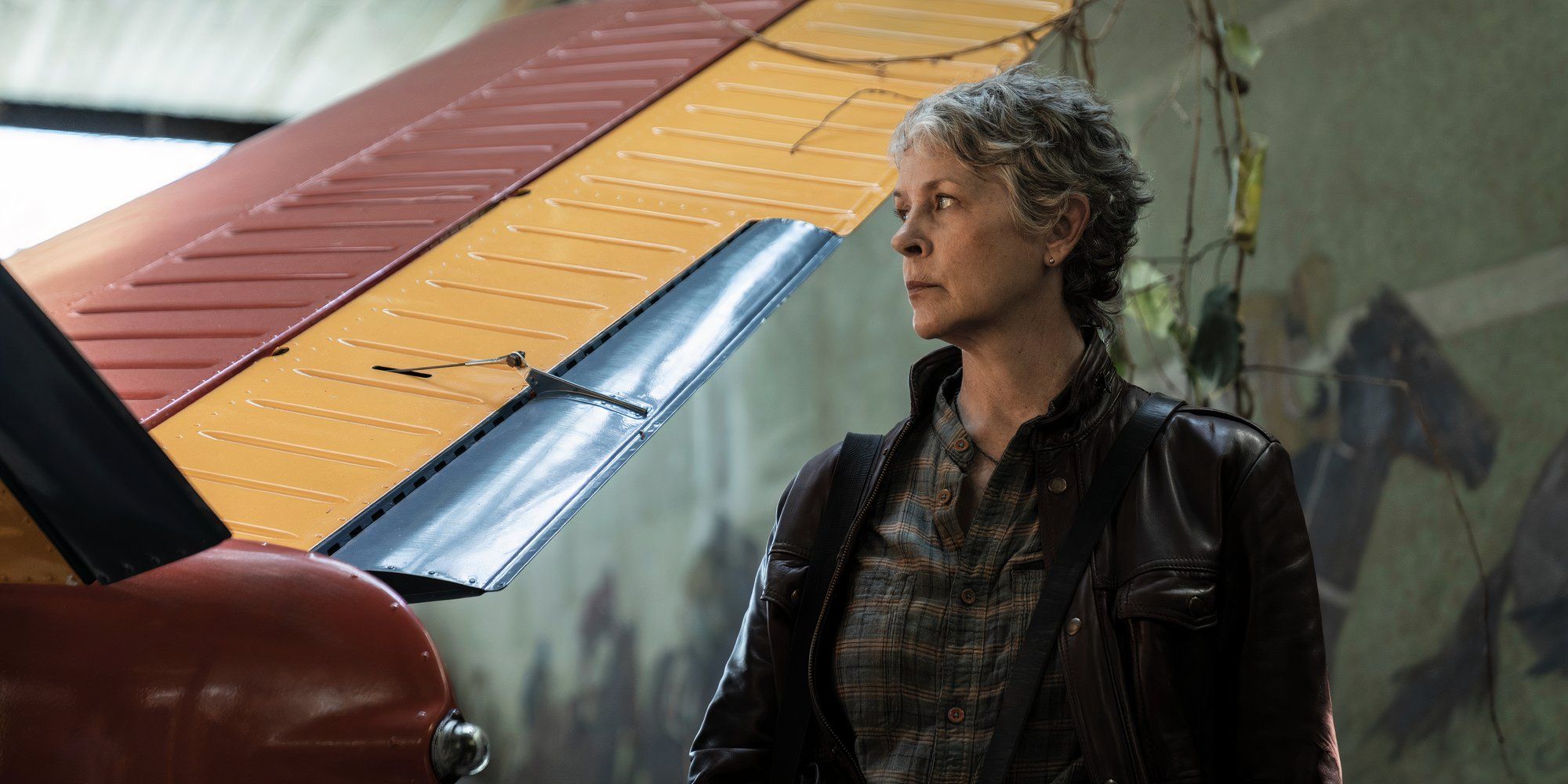 Melissa McBride as Carol standing next to a plane wing in The Walking Dead Daryl Dixon season 2