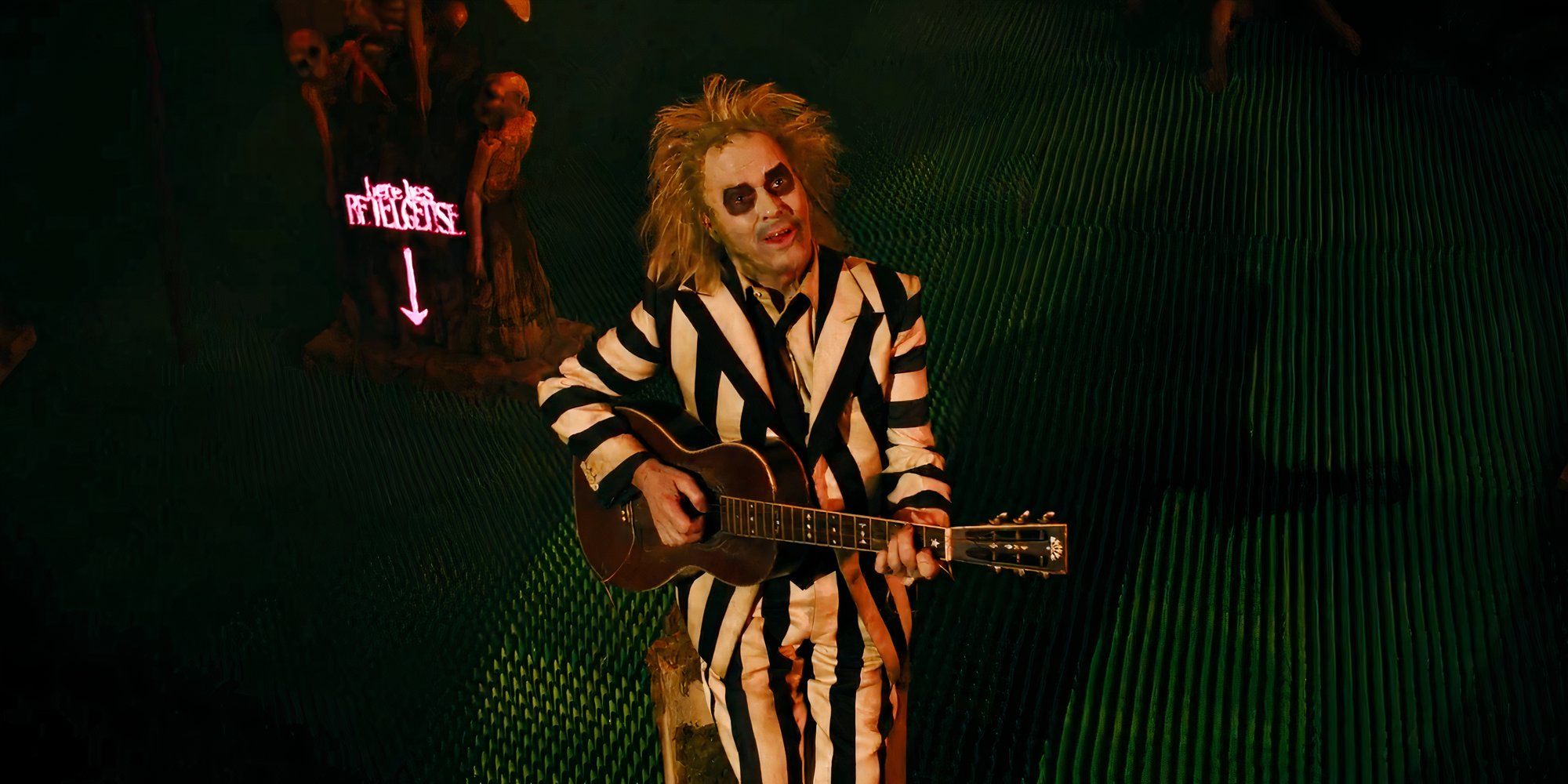 Betelgeuse, interpretada pelo ator Michael Keaton, faz uma serenata para Lydia em Beetlejuice 2, de Tim Burton.