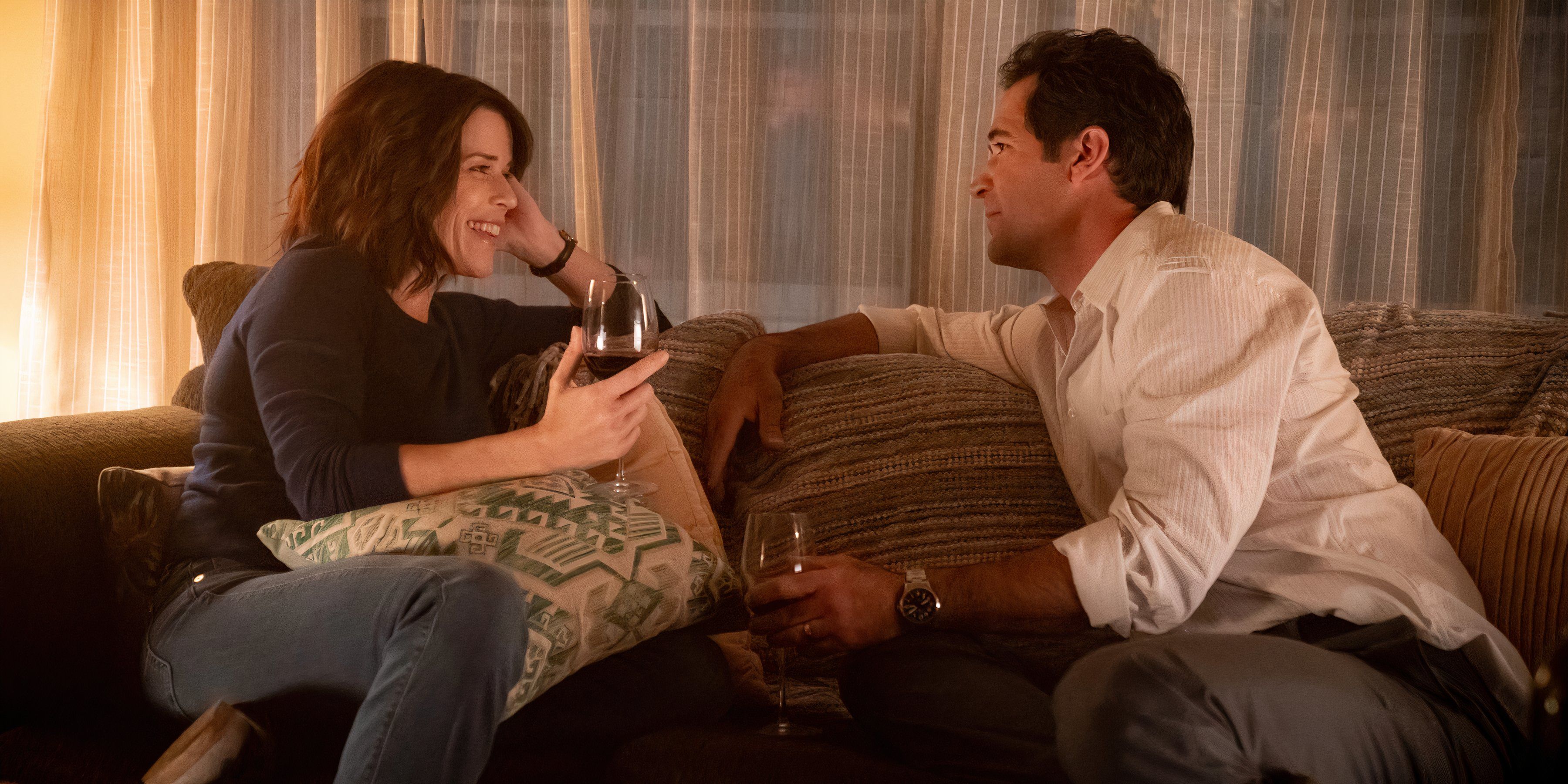 Mickey and Maggie drink wine while sitting on the couch in The Lincoln Lawyer season 3 episode 1