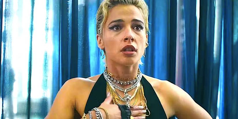 Naomi Scott's Skye Riley takes a breath by a blue curtain in Smile 2