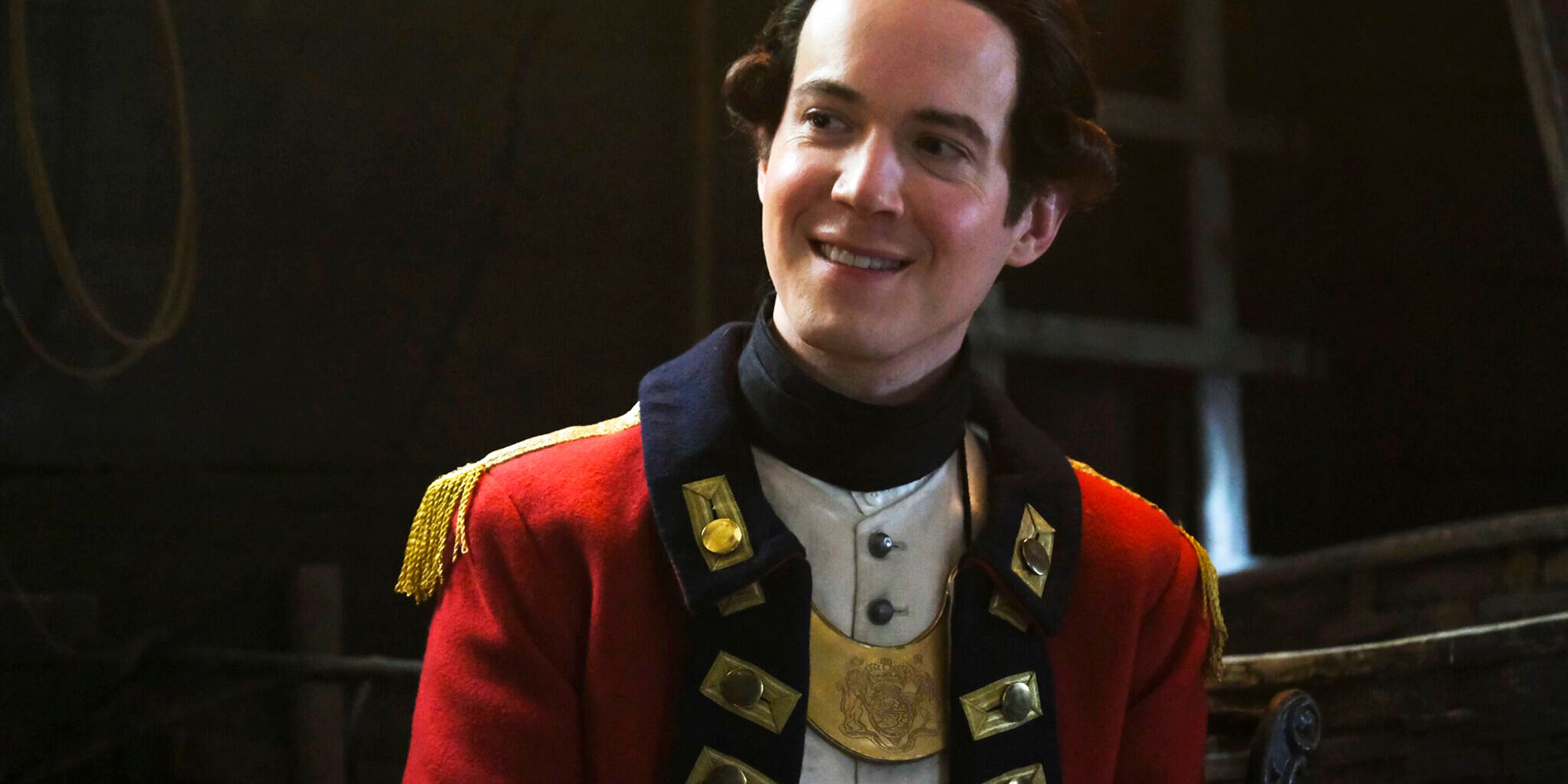 Nigel Chessum smirking in his red uniform in Ghosts