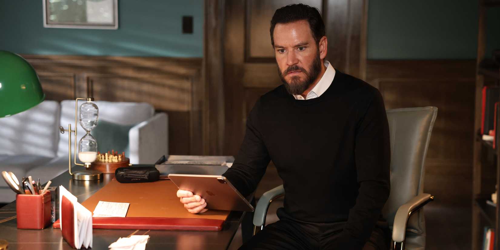 Sir sitting at a desk and looking angry in Found season 2.