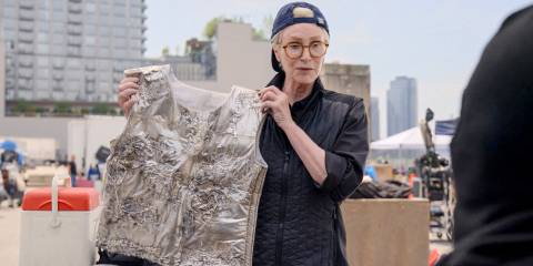 Sazz (Jane Lynch) showing her protégé the flame retardant vest he will wear for the stunt scene in Only Murders in the Building Season 4 Episode 9
