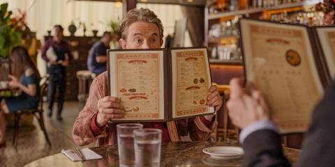 Oliver (Martin Short) covering his face with a menu in Only Murders in the Building Season 4 Episode 9