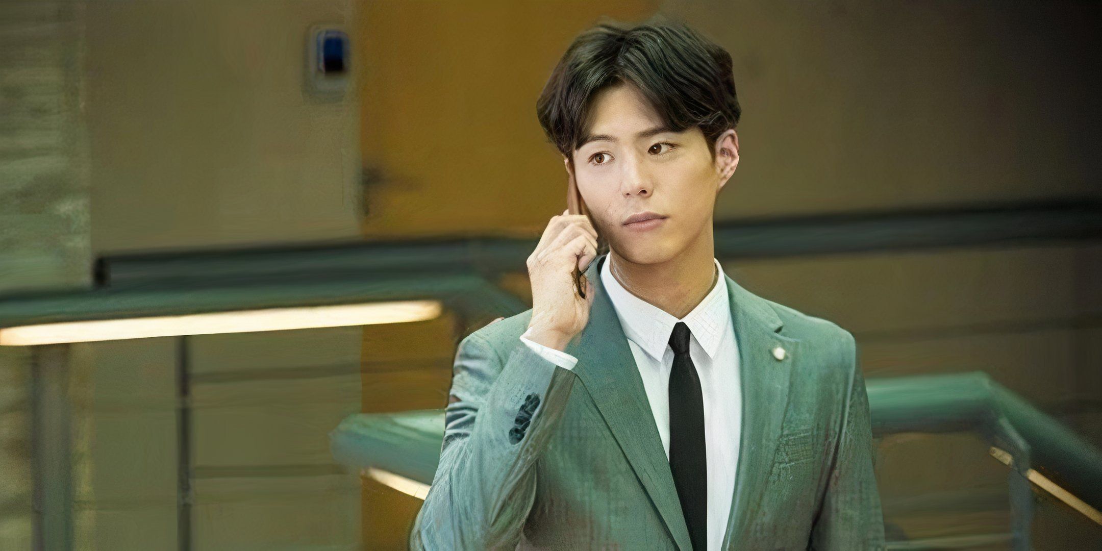 Park Bo-gum holds a phone up to his ear. 