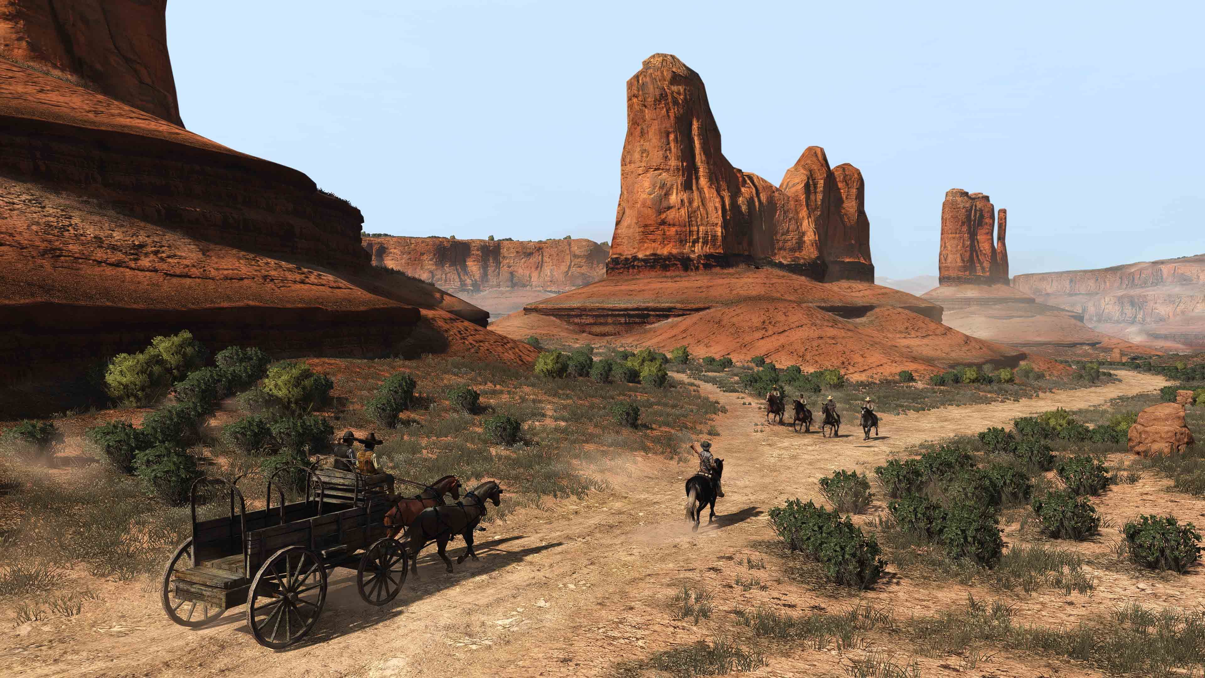 Captura de tela da porta PC de Red Dead Redemption de uma carroça e um homem a cavalo caminhando por uma paisagem árida.