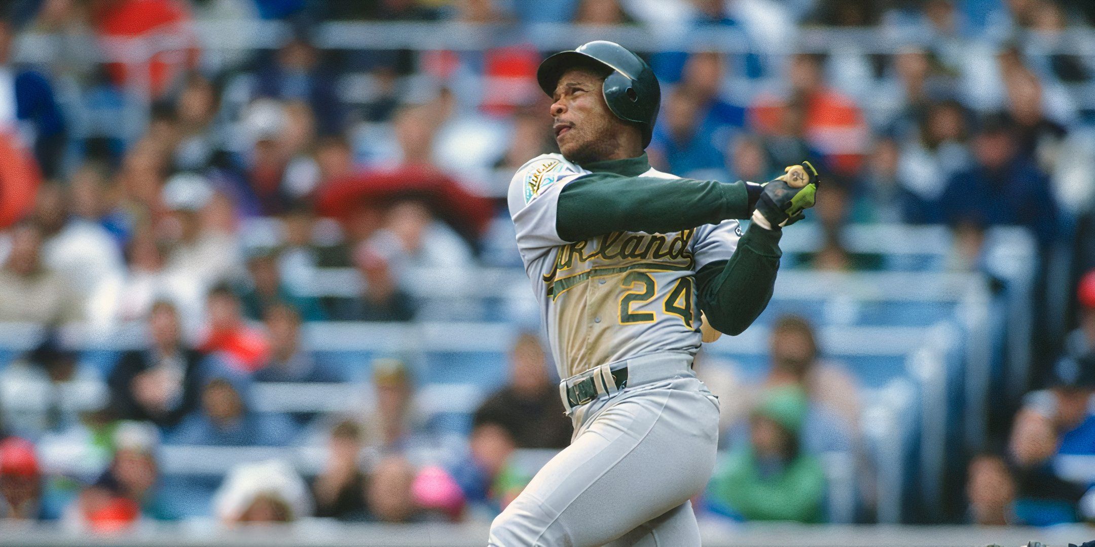 Rickey Henderson no meio do balanço durante um jogo de beisebol