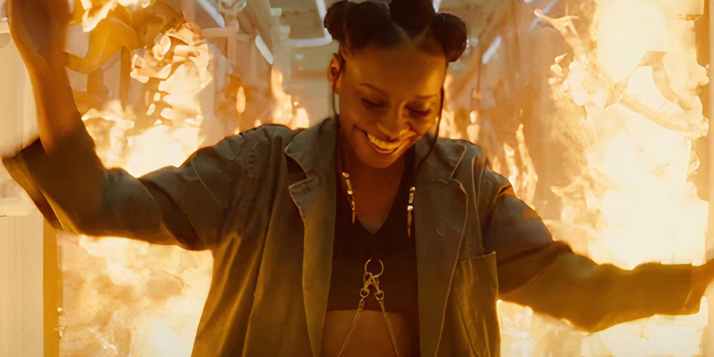 Riri Wililams smiling as a fire roars behind her in Ironheart trailer