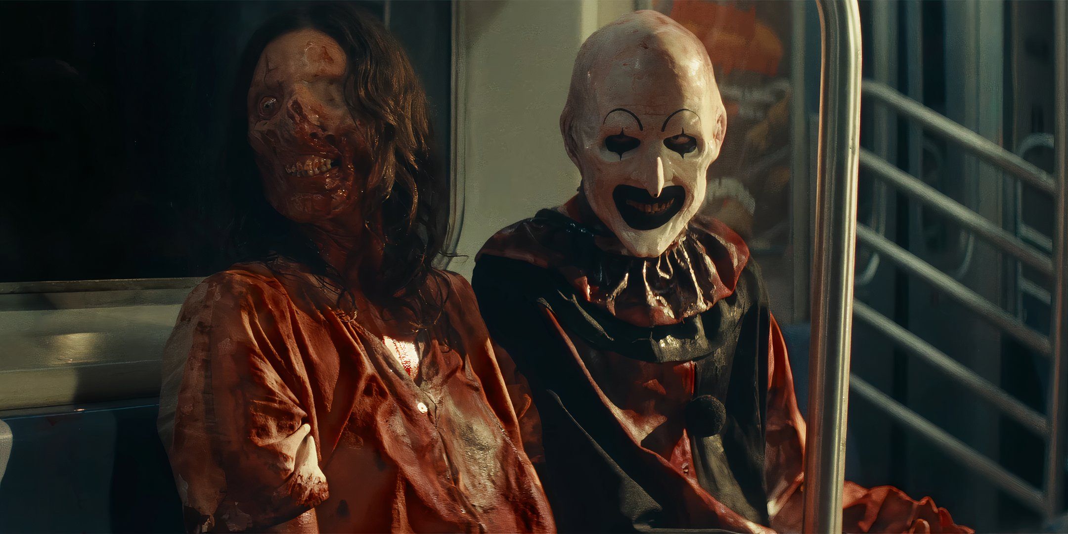 Samantha Scaffidi's Vicky and David Howard Thornton's Art the Clown smiling and covered in blood while sitting on a bus in Terrifier 3