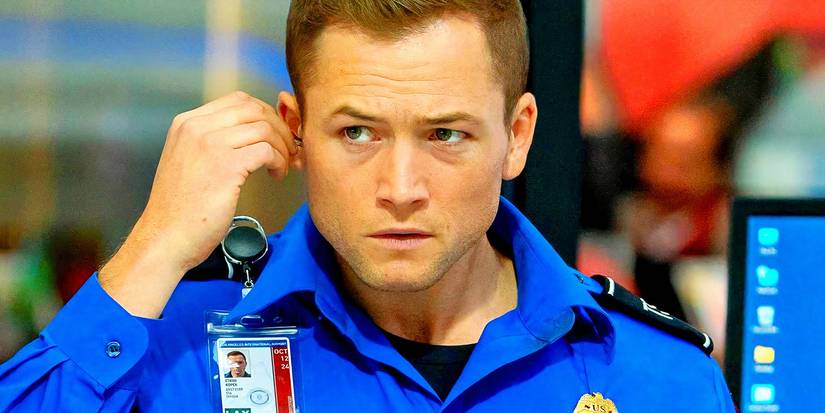 Taron Egerton in uniform touching his earpiece in Carry-On