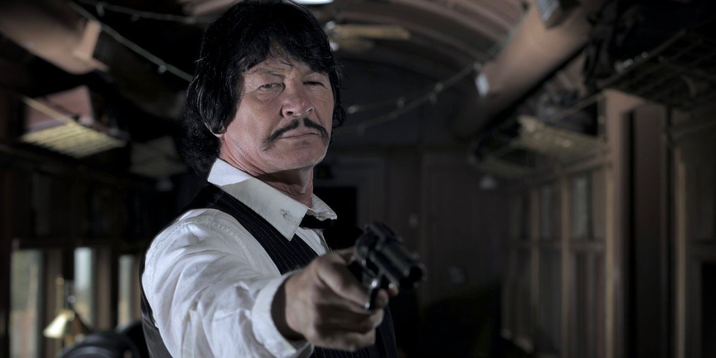 The Colonel (Robert Bronzi) pointing a gun in a train compartment in Once Upon a Time in Deadwood.