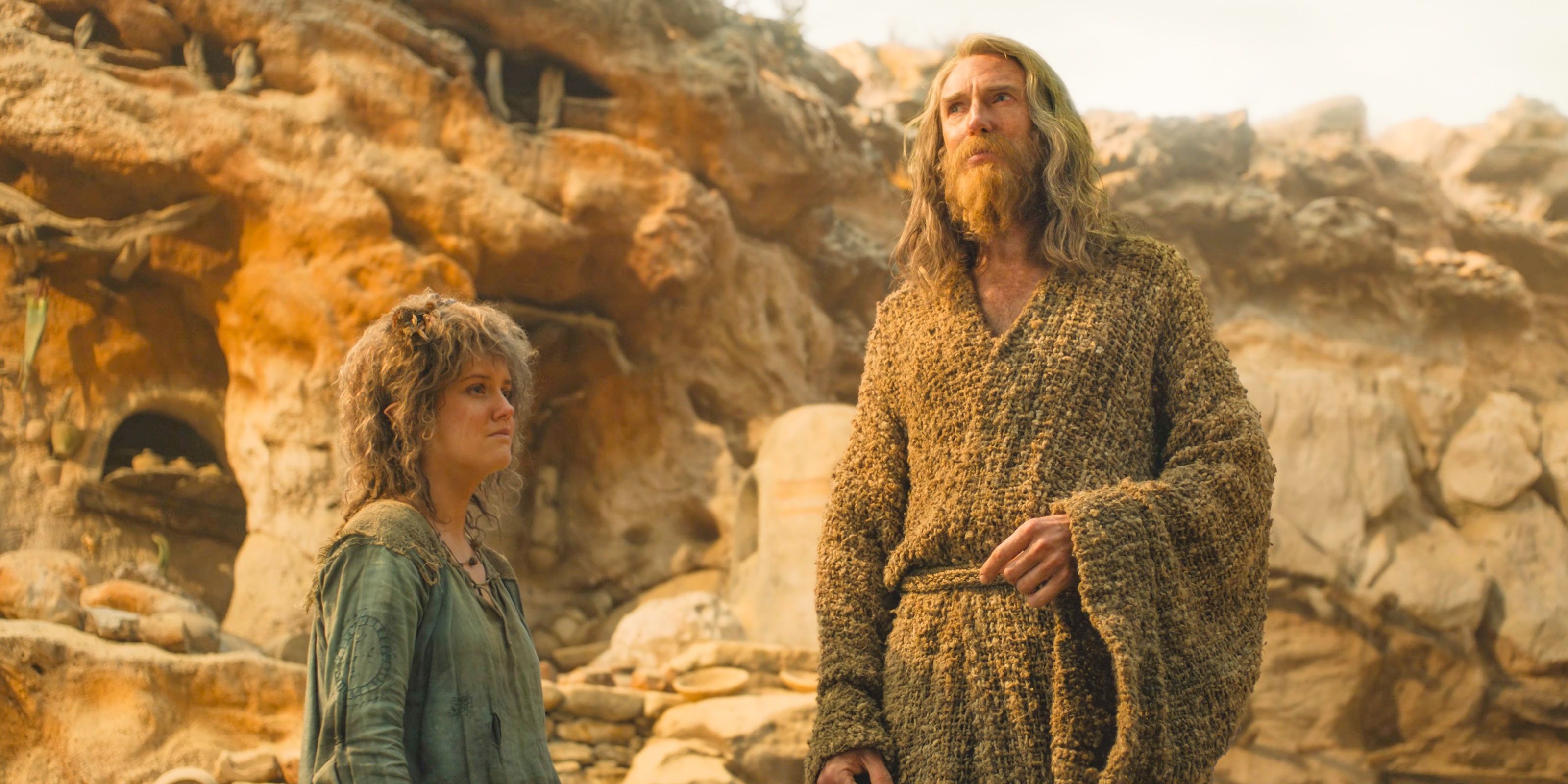 Nori (Markella Kavenagh) and The Stranger (Daniel Weyman) saddened by the destruction of the Stoors' village in The Lord of the Rings: The Rings of Power Season 2 Episode 8