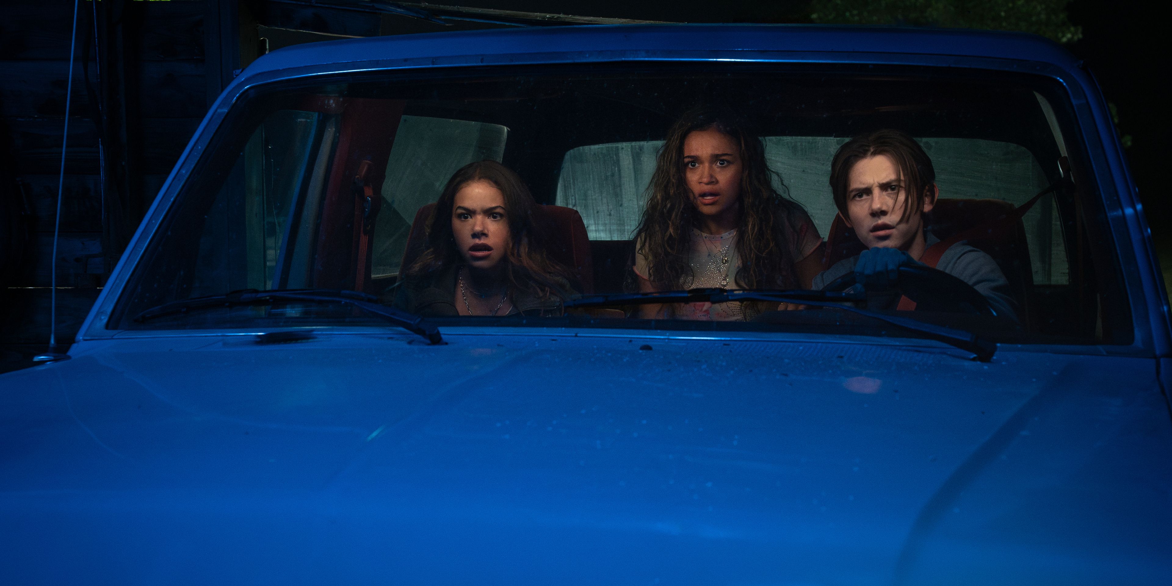 Three teens in a truck staring out at the road in shock in Time Cut