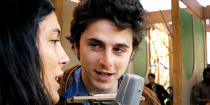 Timothee Chalamet as Bob Dylan singing on stage with another musician in A Complete Unknown trailer