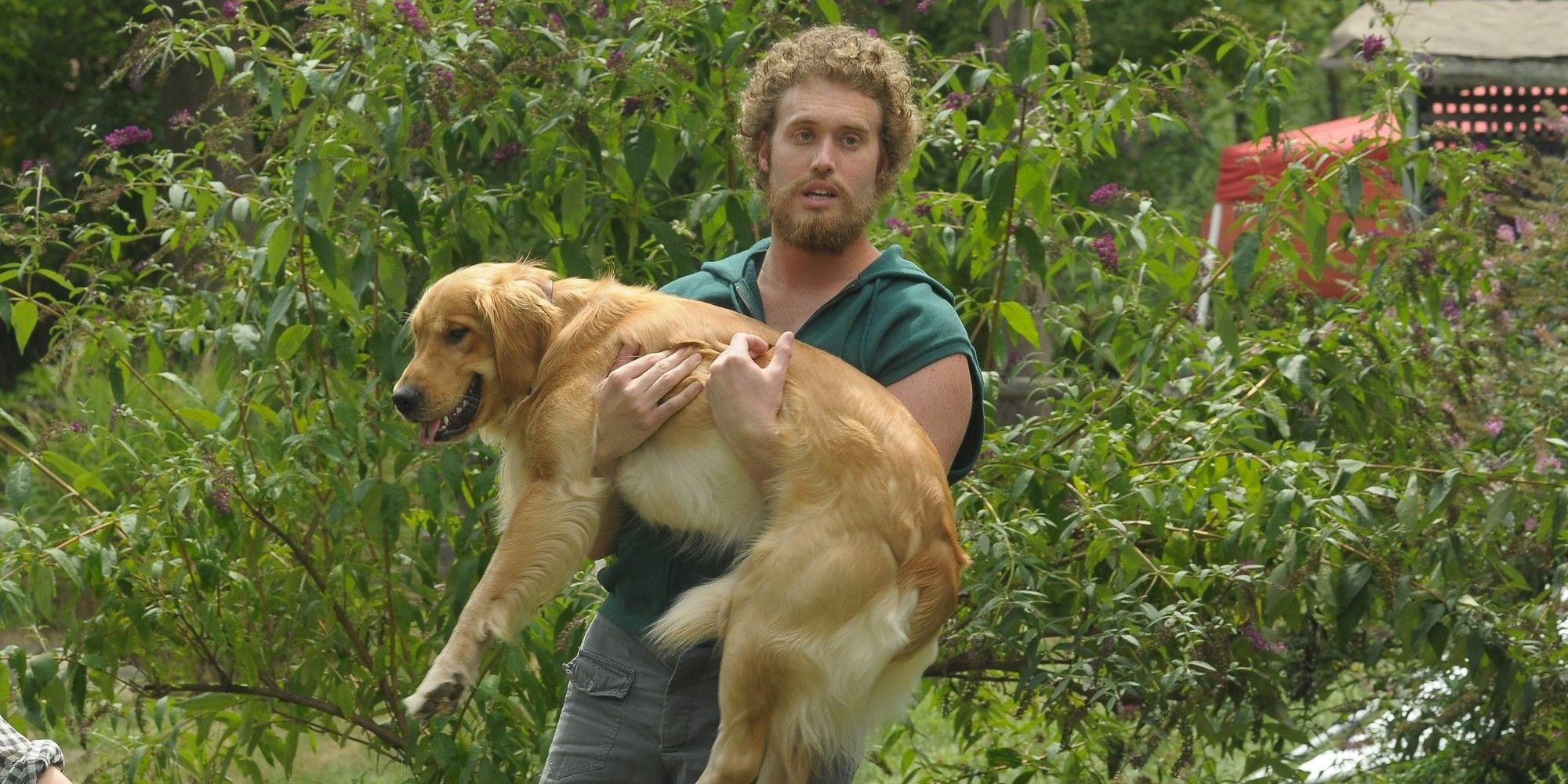 TJ Miller como Billy segurando um cachorro em Our Idiot Brother