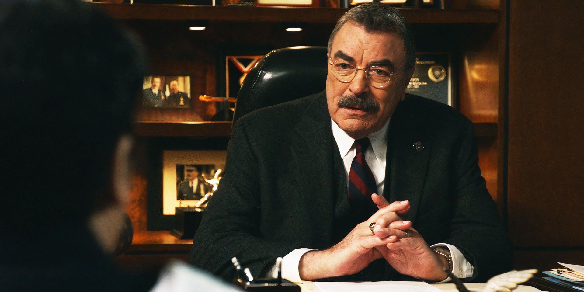 Tom Selleck as Frank behind a desk in the 14th season of Blue Bloods