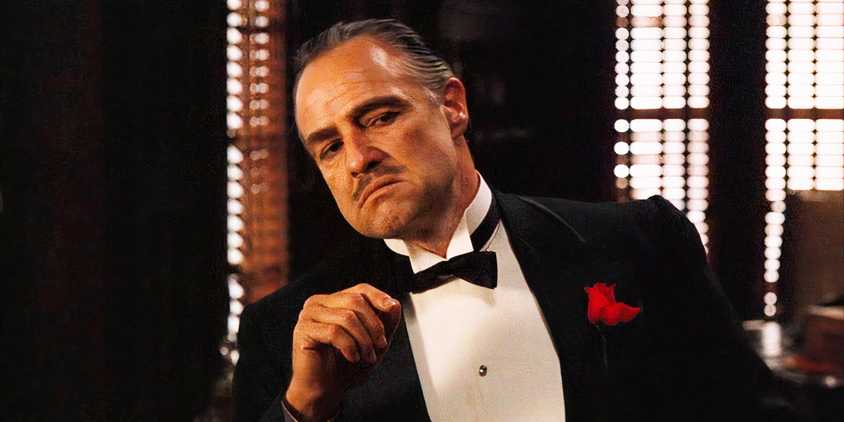 Marlon Brando as Don Vito Corleone leaning in The Godfather.
