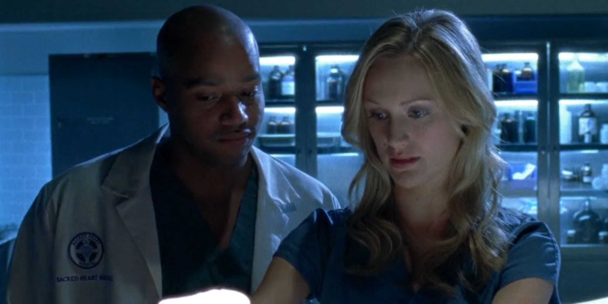 Donald Faison como Turk in Scrubs assistindo Lucy Bennett de Kerry Bishé trabalhar