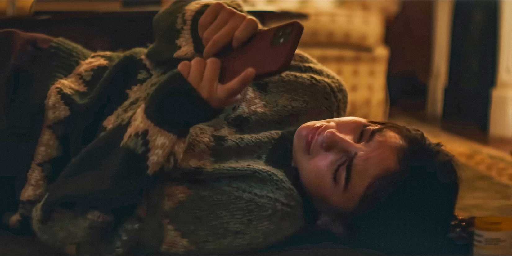 Laura Franco (Melissa Barrera) crying while looking at photos on the phone in Your Monster