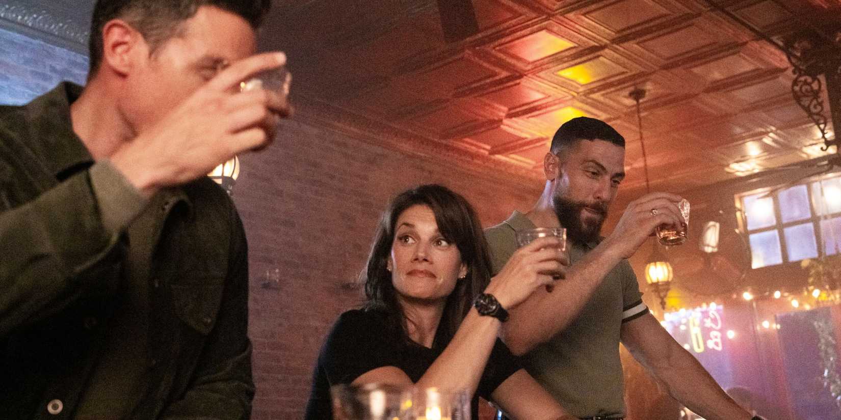 FBI the team holding up their glasses for a toast in a bar