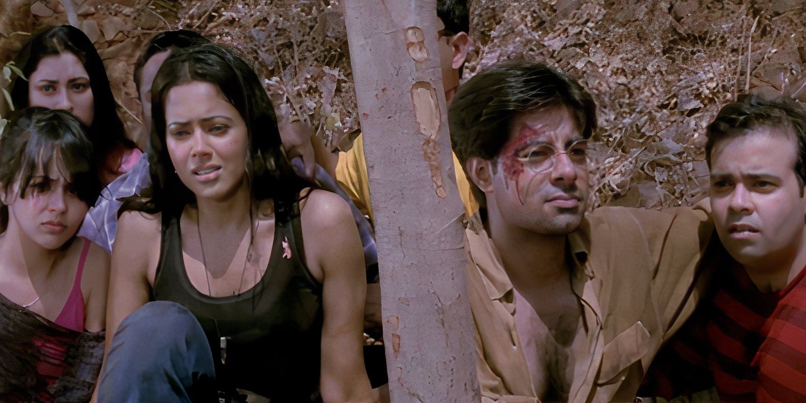 A group of young people look apprehensive sitting together by a tree in the Indian horror movie Darna Mana Hai