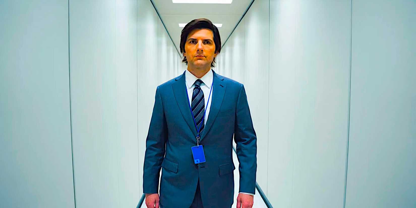Adam Scott wears a blank expression walking down a sterile hallway in Severance season 1