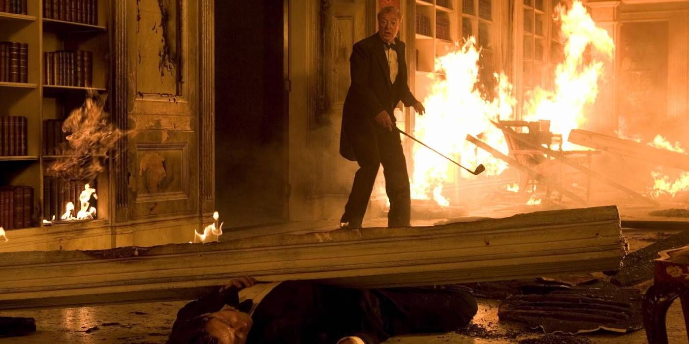 Alfred looking at Bruce Wayne trapped in wayne manor fire in Batman Begins