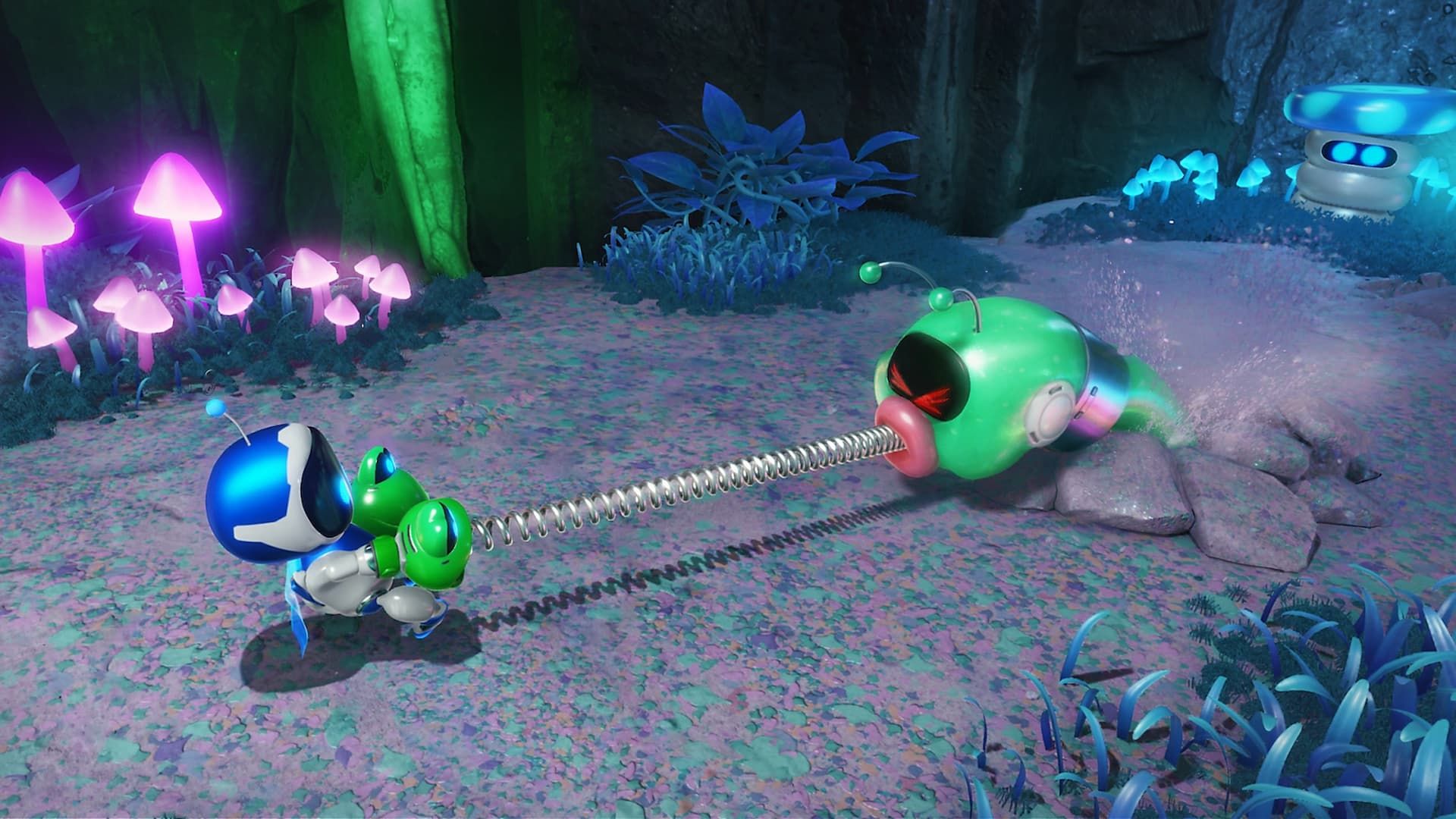 Astro Bot lutando com um monstro robótico verde dentro de uma caverna cheia de cogumelos coloridos. 