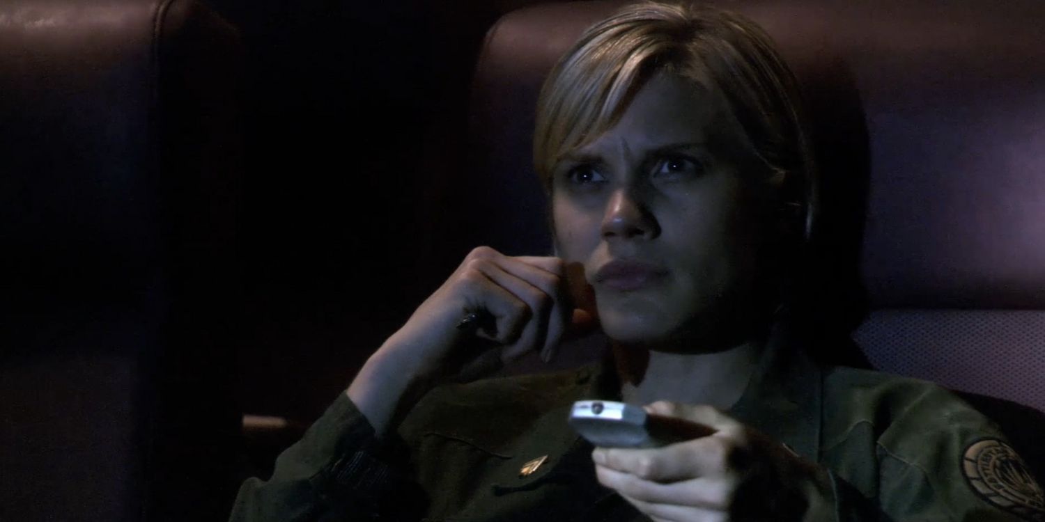 Starbuck de Battlestar Galactica revisa con preocupación las imágenes del vuelo en el episodio Hero