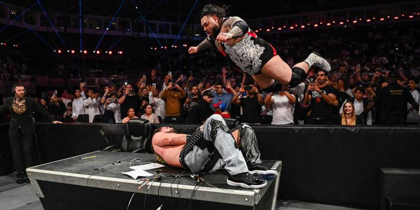 Bronson Reed hits the Tsunami splash on Seth Rollins on WWE Monday Night Raw through an announcer table