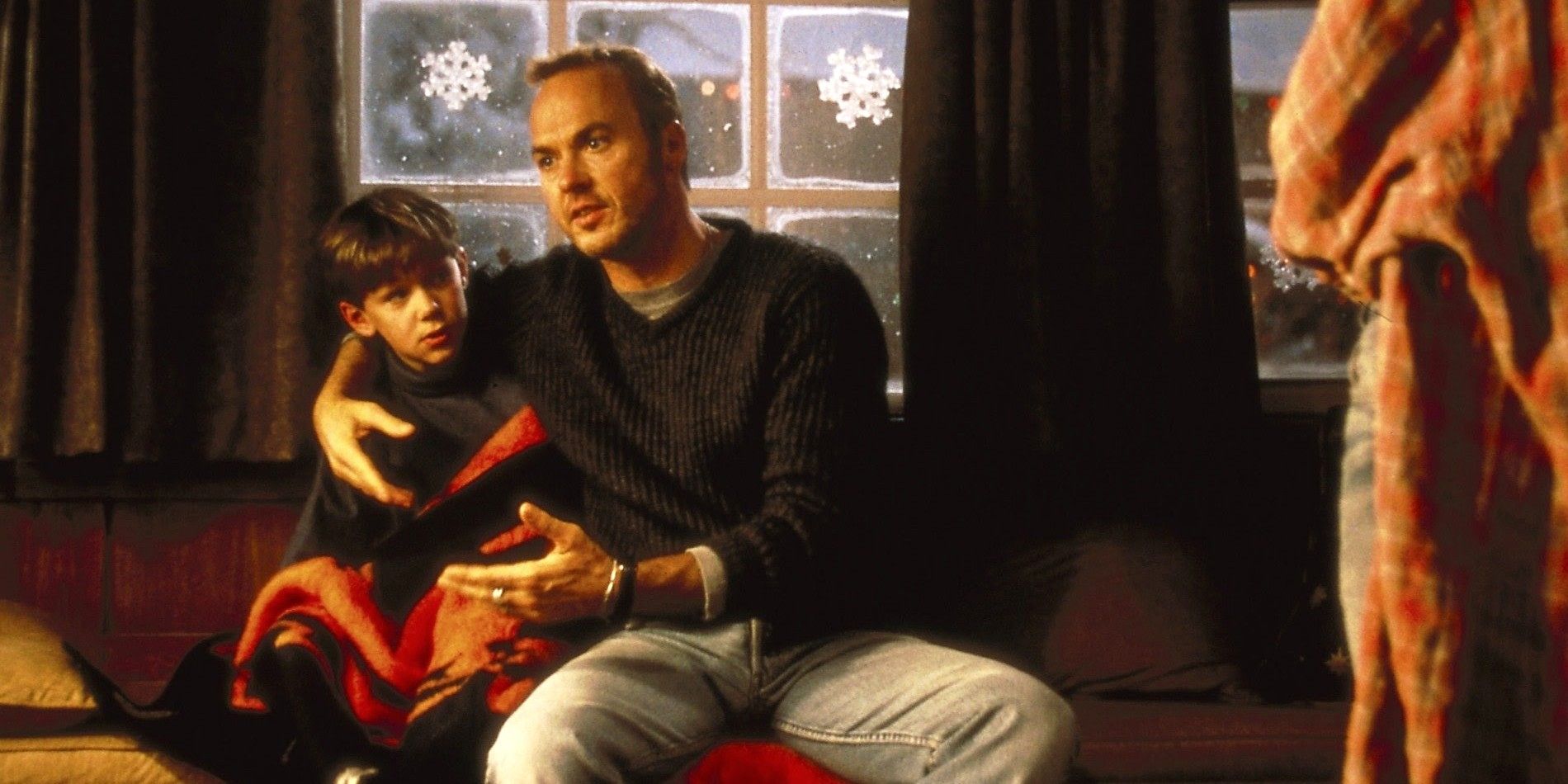 Charlie y Jack (Michael Keaton) están sentados en el sofá hablando en Jack Frost 1998