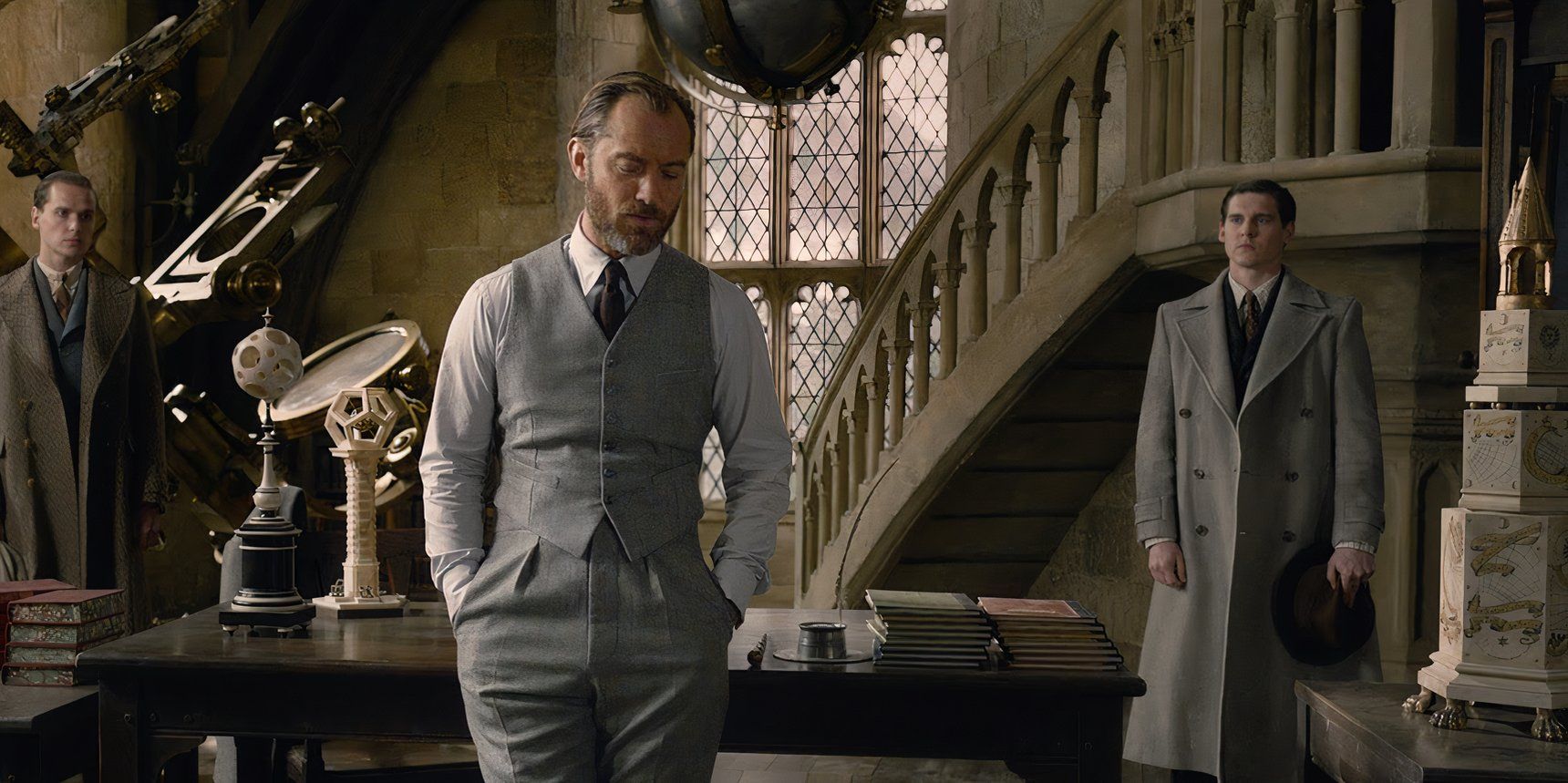 Dumbledore leaning against a desk and speaking to aurors in The Crimes of Grindelwald