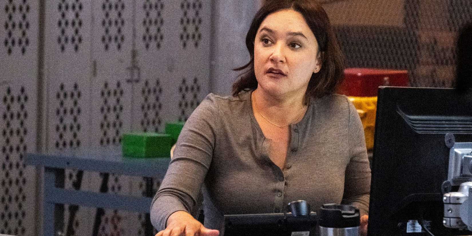 FBI: Most Wanted Hana sitting at a computer with a coffee thermos
