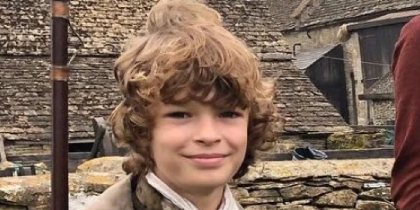 Jeremy Poldark (Oscar Novak) segurando um rifle e sorrindo em Poldark