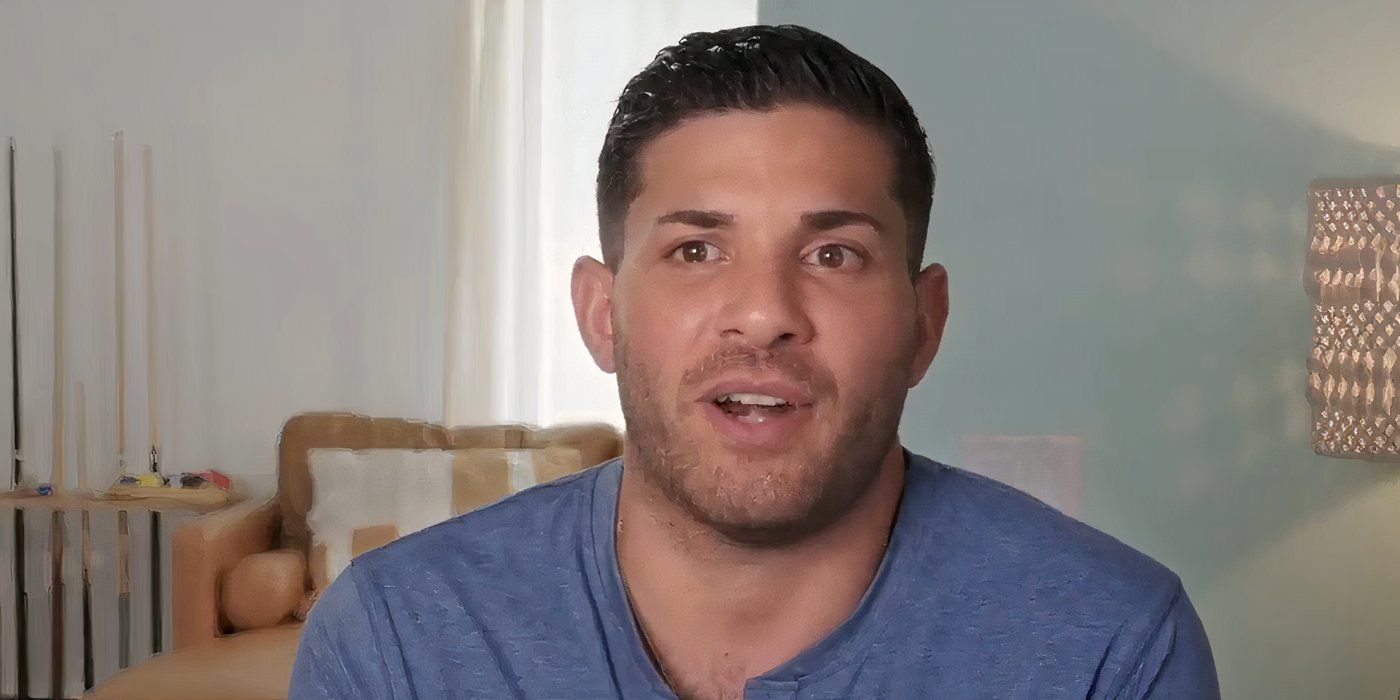 Joe Coan In 90 Day Fiance in confessional wearing blue shirt smiling