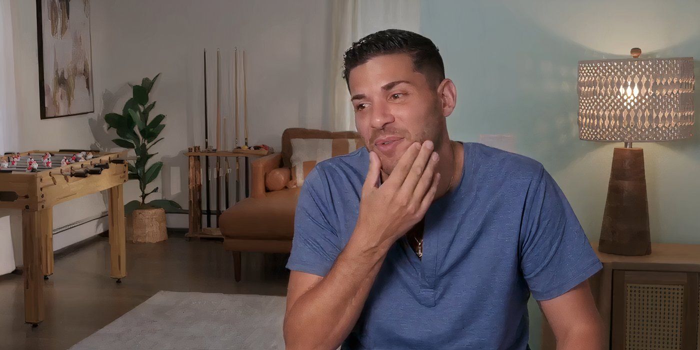 Joe Coan In 90 Day Fiance touching his face wearing blue t-shirt