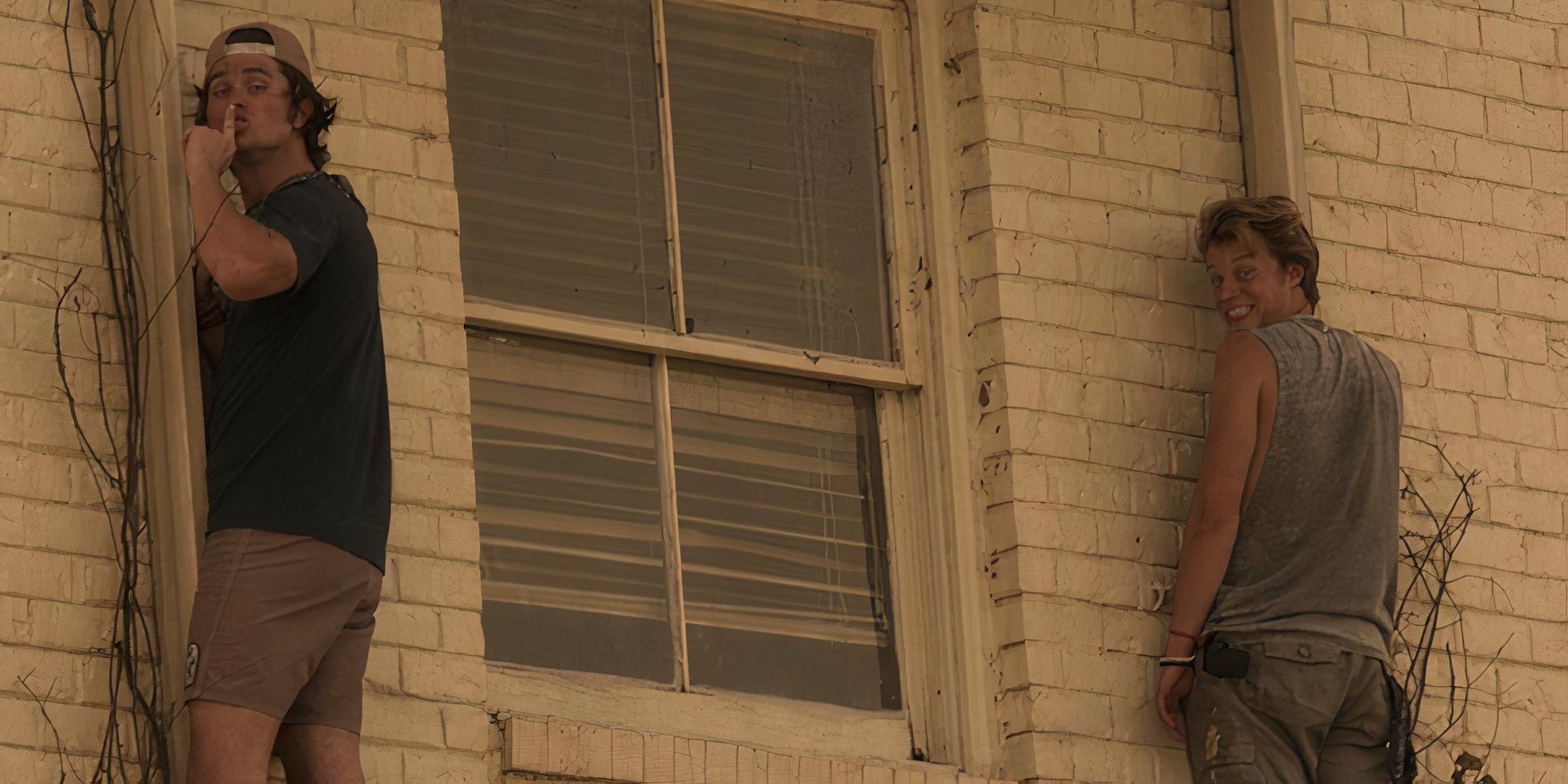 John B and JJ on the outside of a motel holding onto the drain pipes in the Outer Banks pilot episode