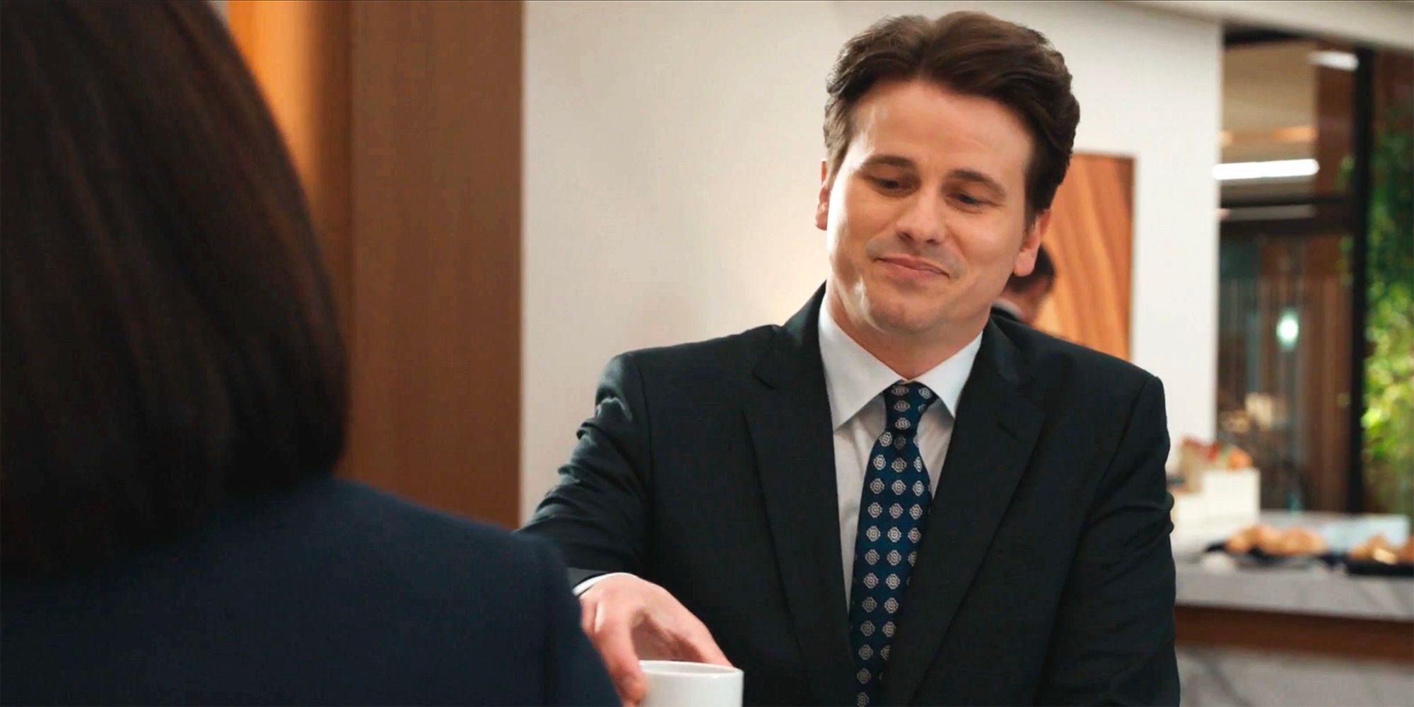 Julian smiling and handing Olympia her coffee in Matlock